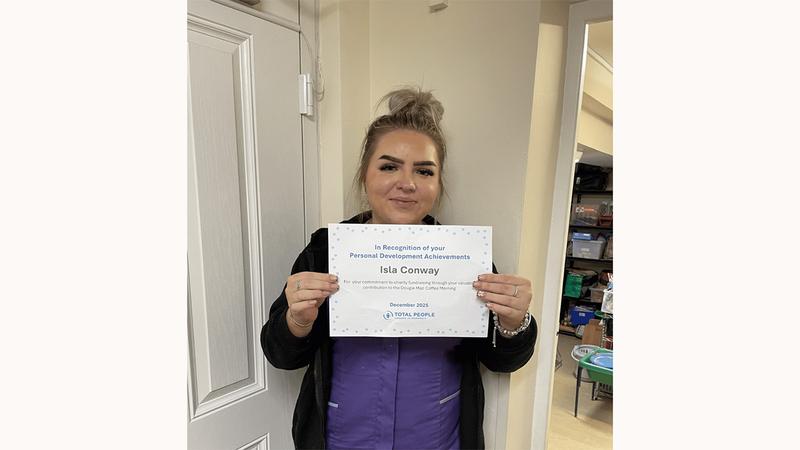 Learner holding her certificate
