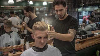 A barber cutting a customers hair