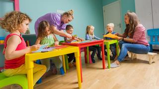 childcare setting with two nursery workings and young children doing creative tasks