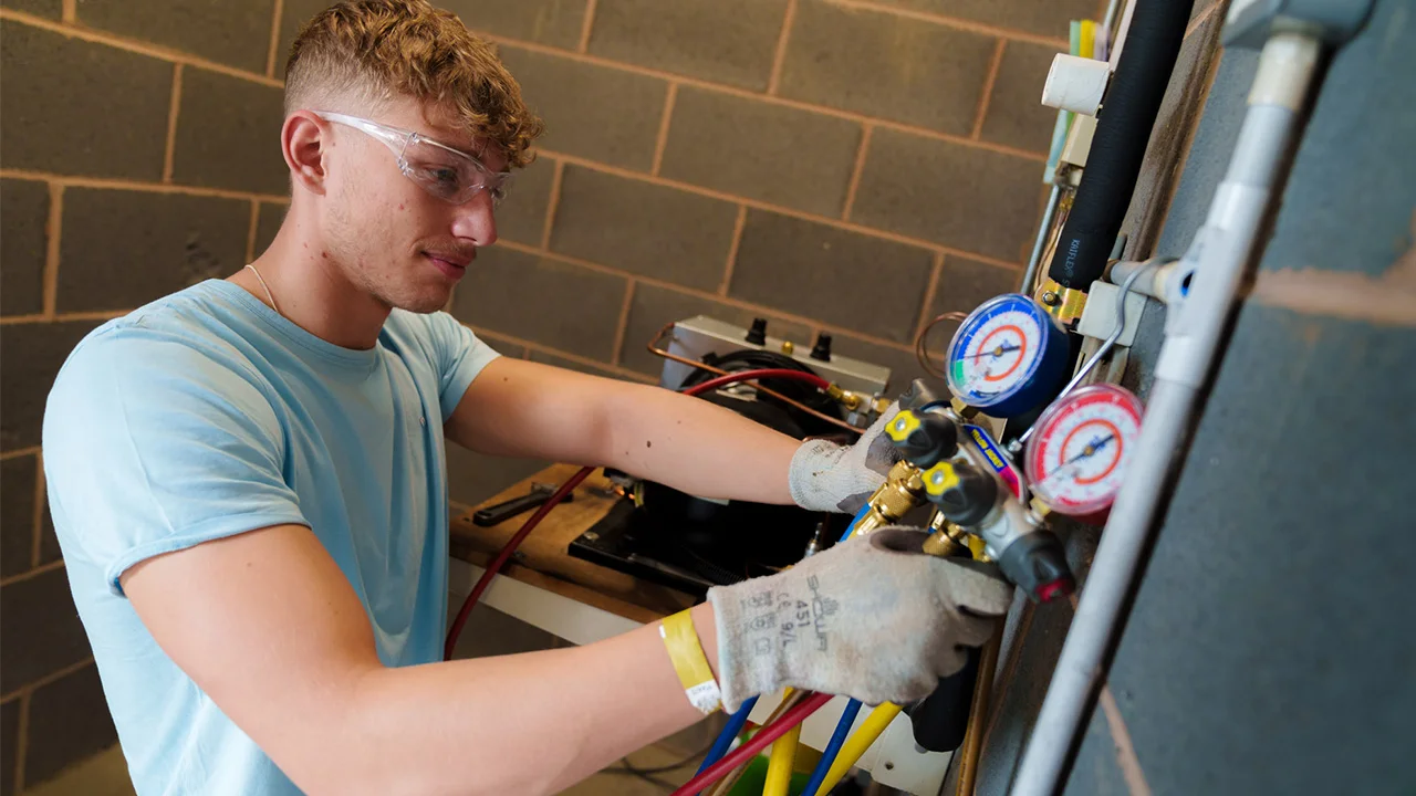 An apprentice technician working on a piece of equipment