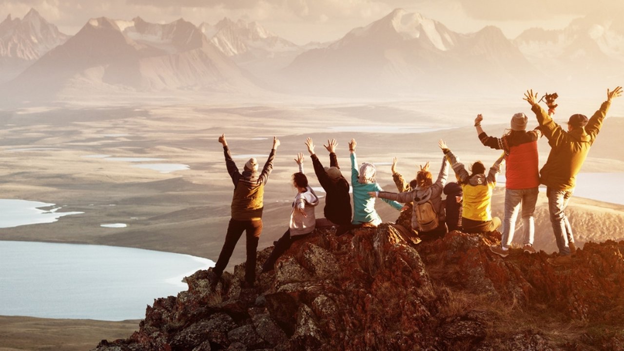 People celebrating their success on the top of a mountain