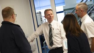 Man in shirt talking to colleagues