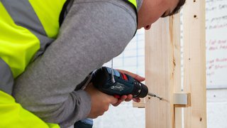 A joinery apprentice with power tool.