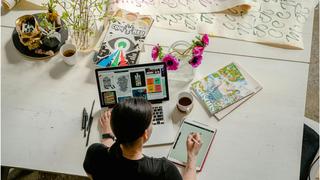 Woman sat on her desk working her desktop