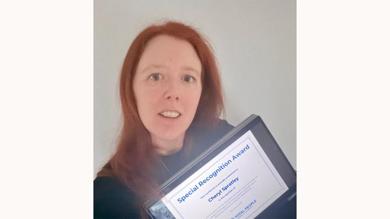 Cheryl Spratley holding a Special Recognition Award certificate