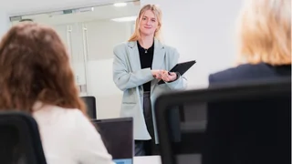 Colleaague standing infront her peers