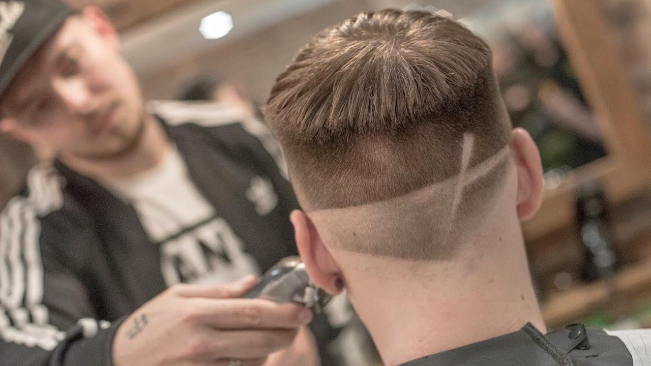 A barber styles customer's hair.