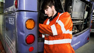 Commercial vehicle apprentice repairing a bus.