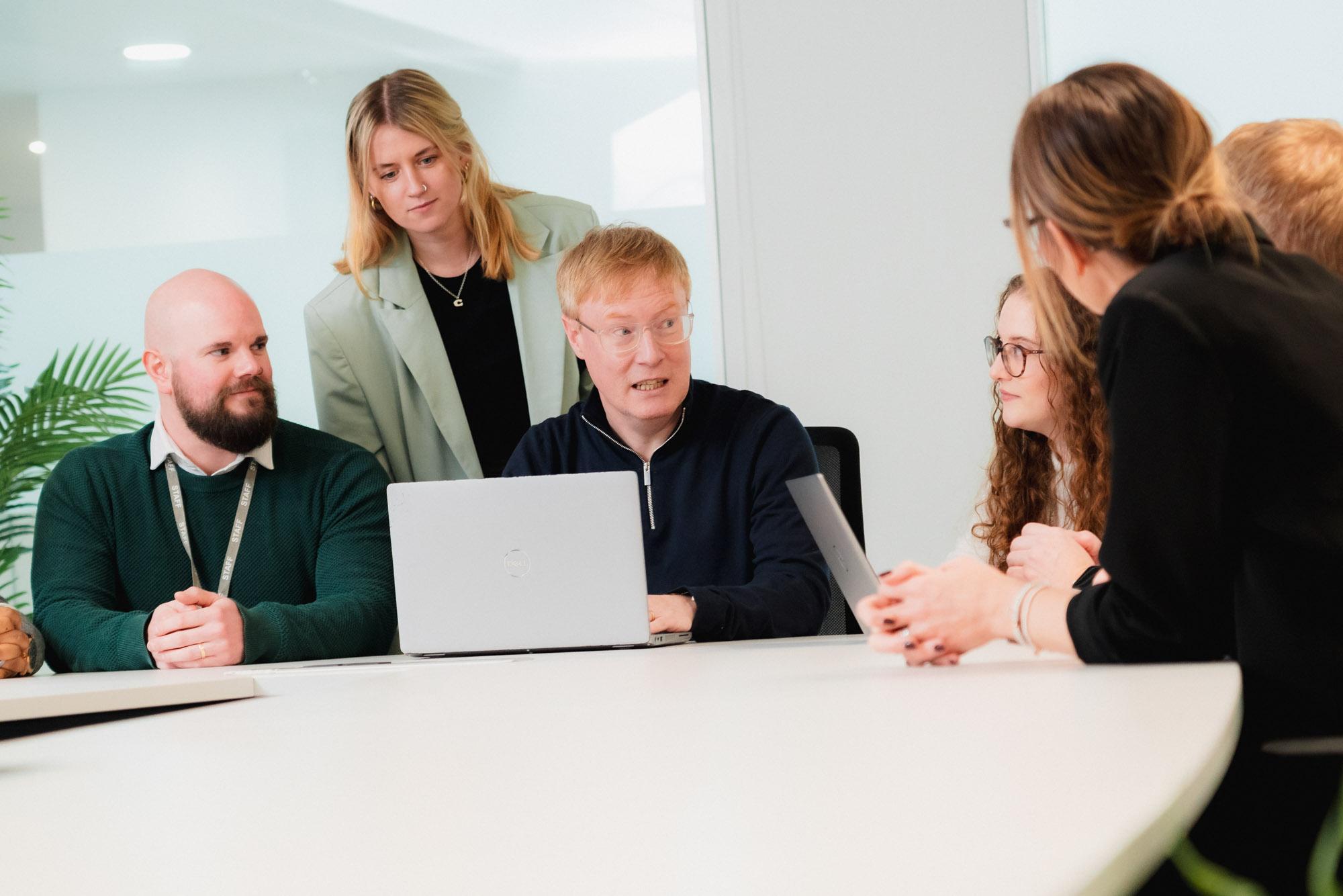 people chatting around a laptop