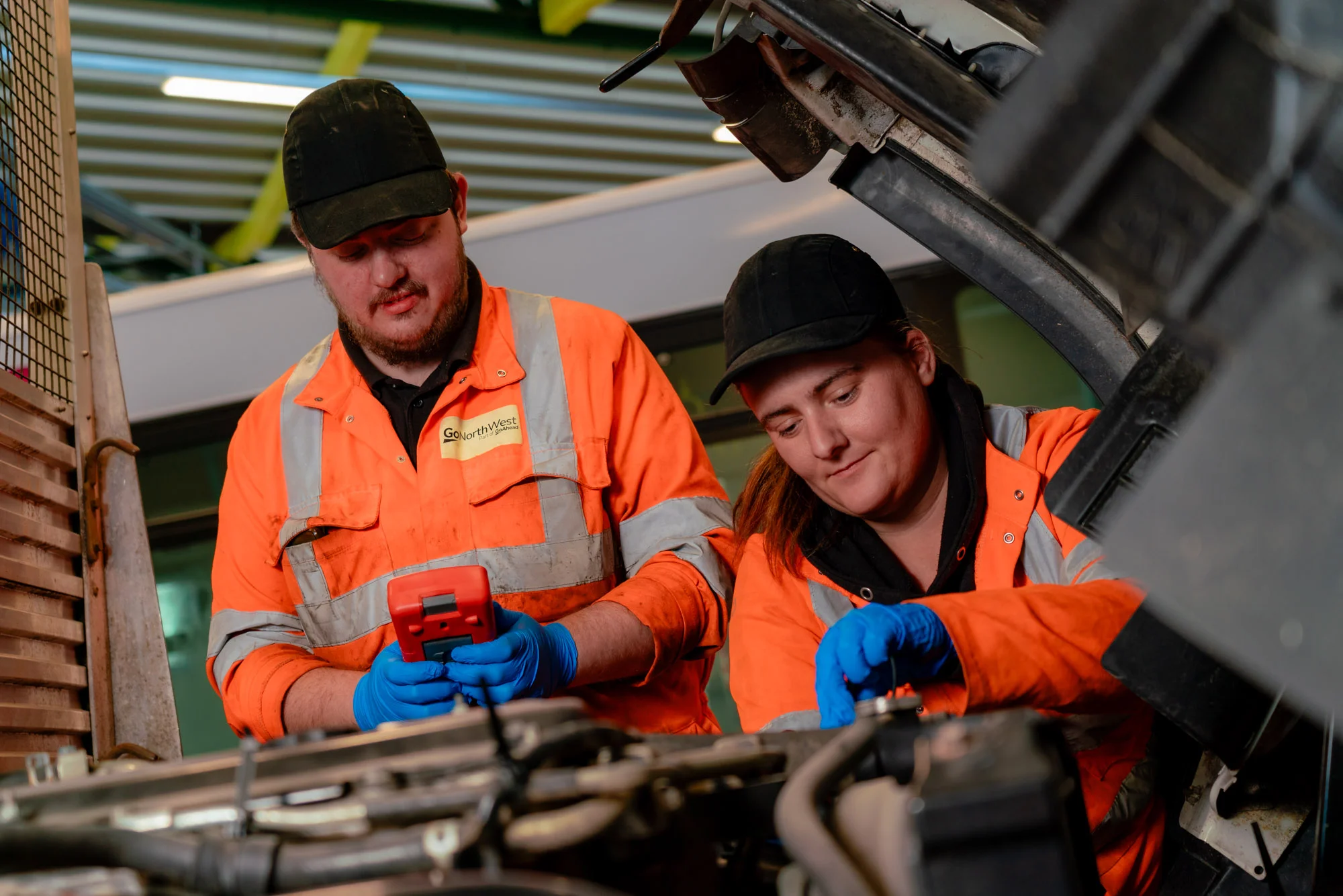 Man and lady working on the inside of a vehicle