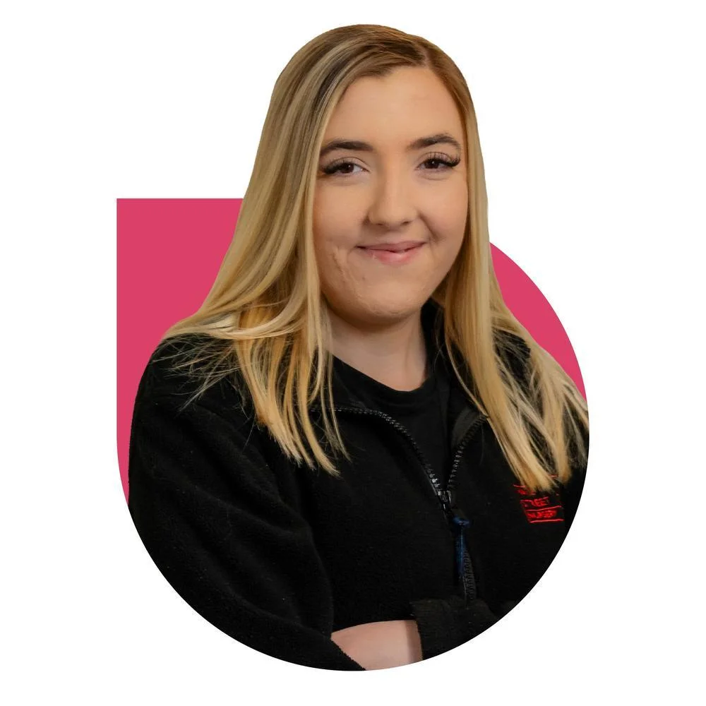 Learner wearing a black nursery-branded fleece, posing in front of a coloured graphic background.