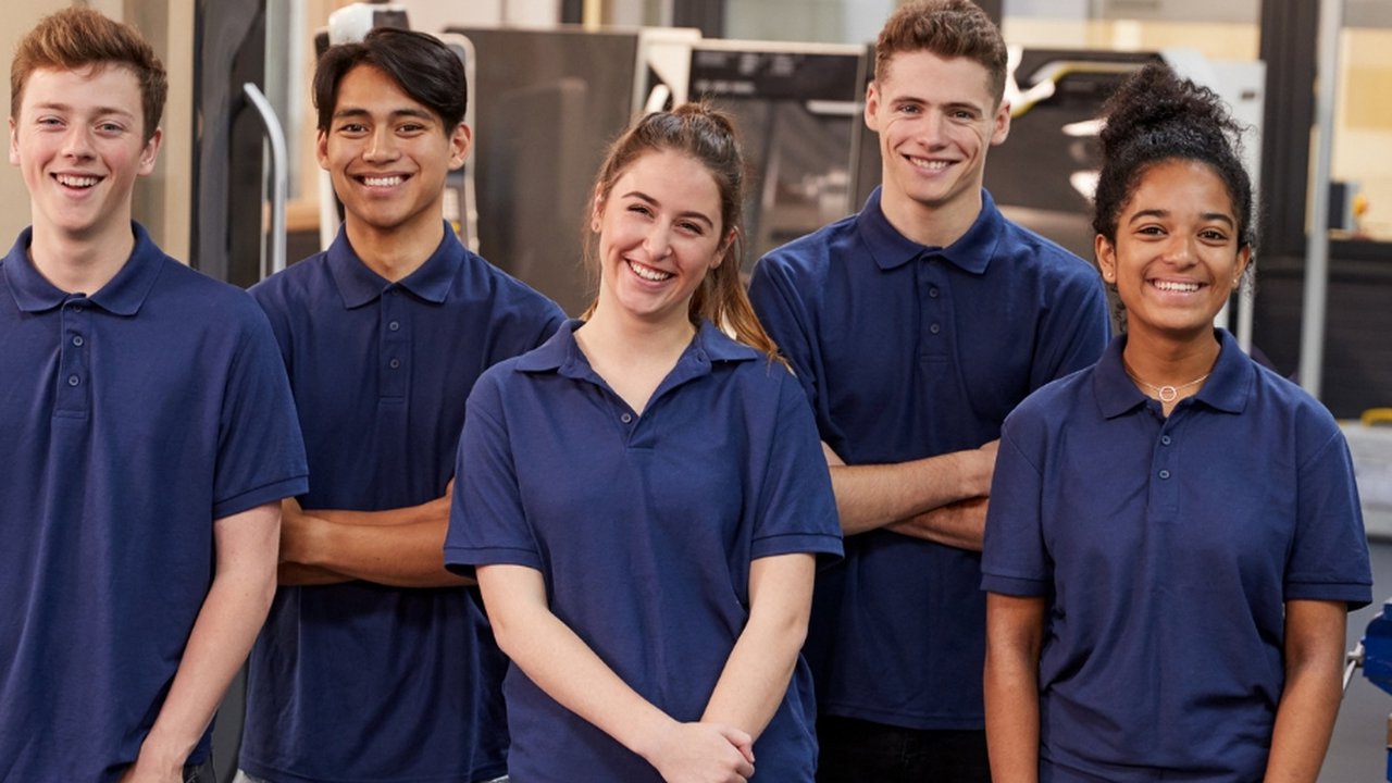 A group of young apprentices stood smiling