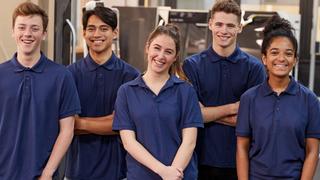 A group of young apprentices stood smiling