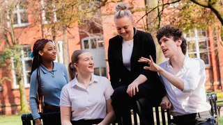 group of people sitting on a bench chatting