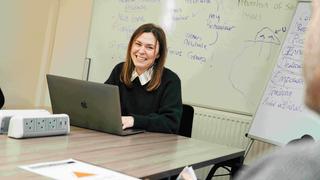 girl smiling at camera with a laptop
