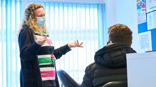 Learning coach speaking to a learner in the classroom.