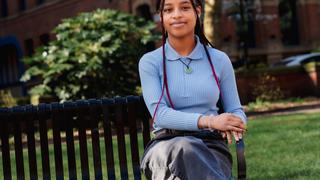 A young lady sat on a park bench