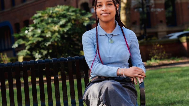 A young lady sat on a park bench