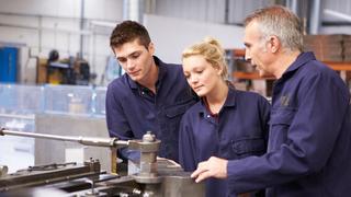 A tutor instructing two apprentices