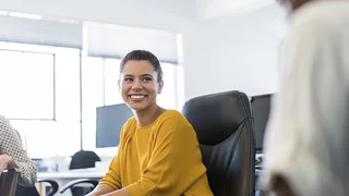 lady sat at a desk smiling