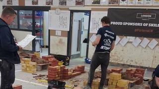 Student bricklayer laying bricks