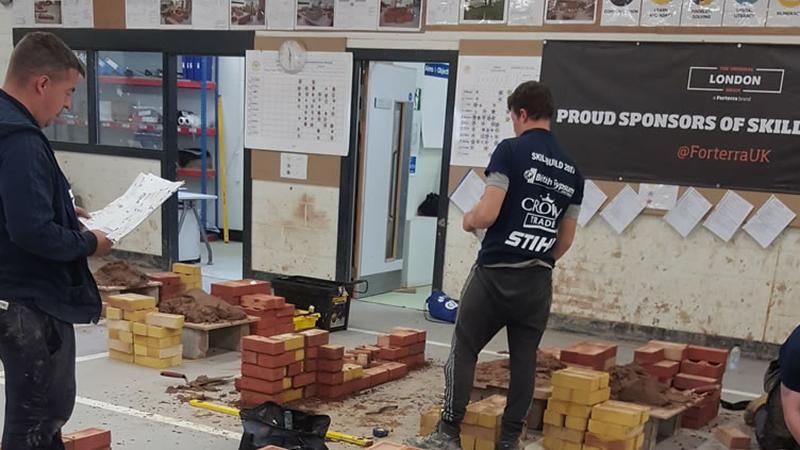 Student bricklayer laying bricks