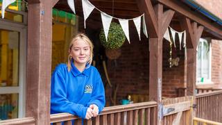 An Early Years apprentice poses for a photo outside the nursery she works at.