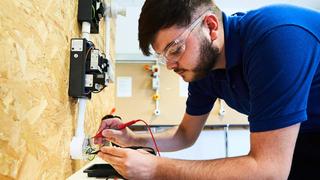 Electrical apprentice fixing wiring.