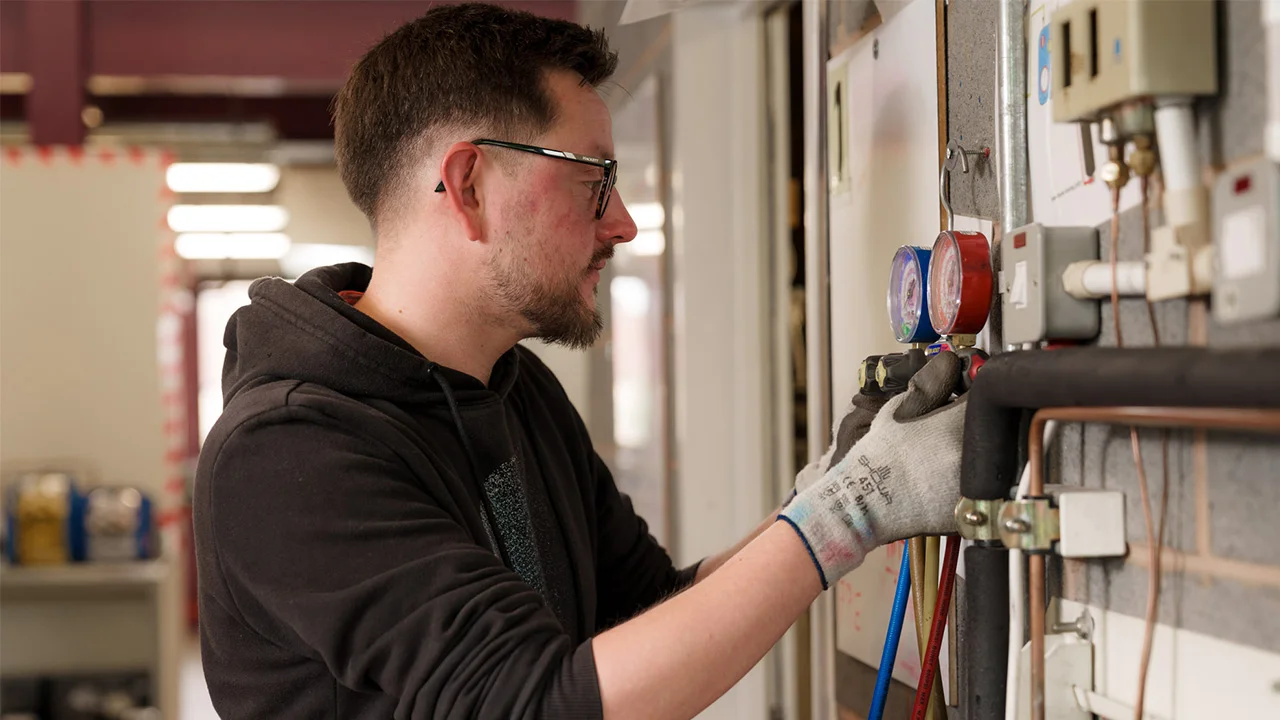 An apprentice technician working on a piece of equipment