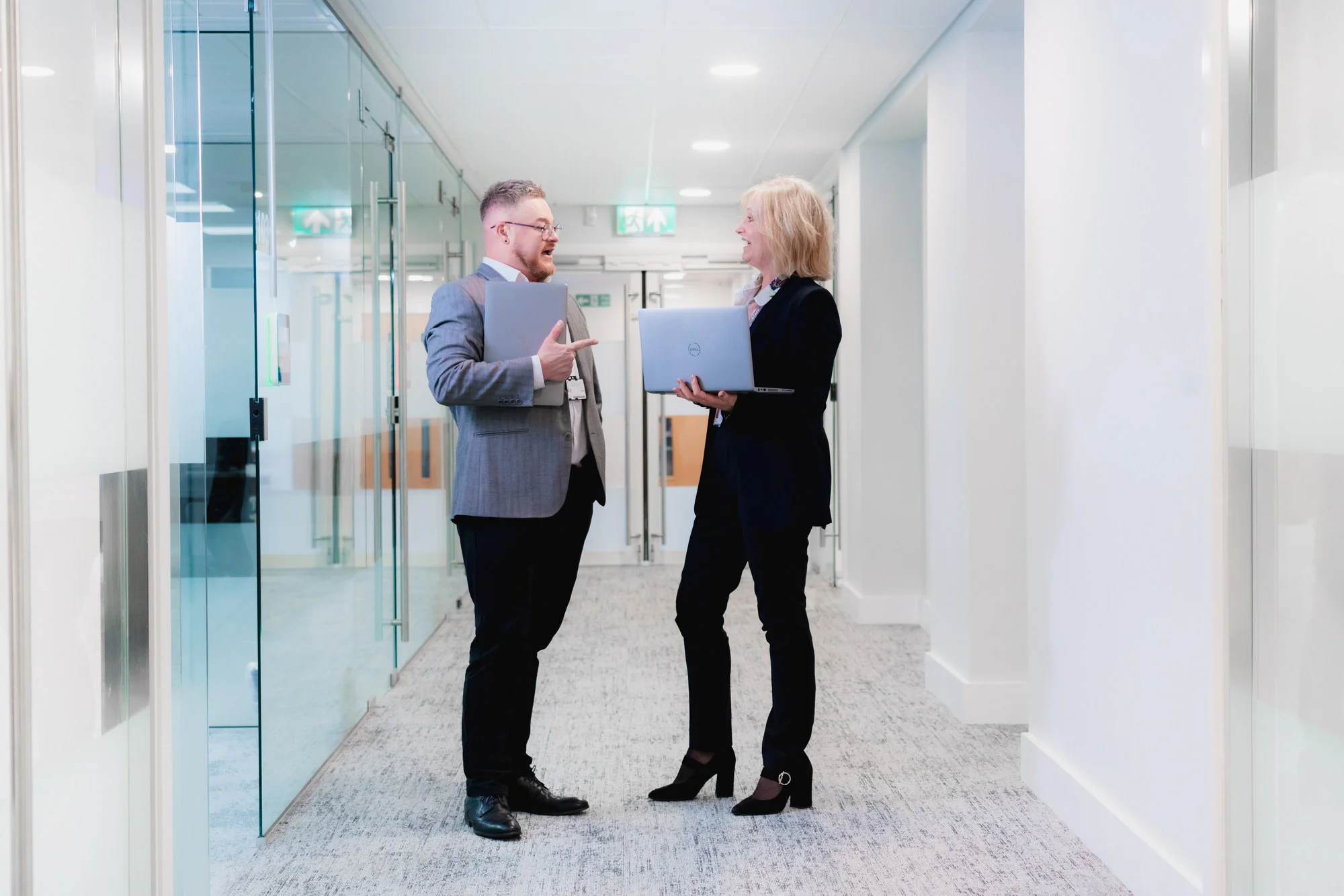 two people standing with a laptop having a chat