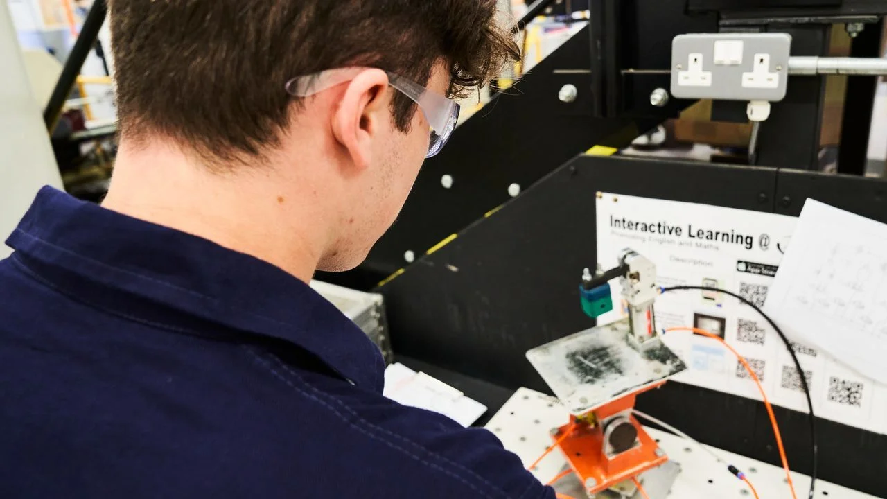 Engineering student working with electrical components and technical diagrams in a practical learning environment