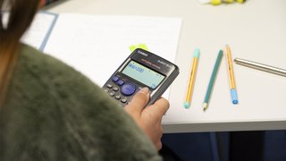 Apprentice holding a calculator