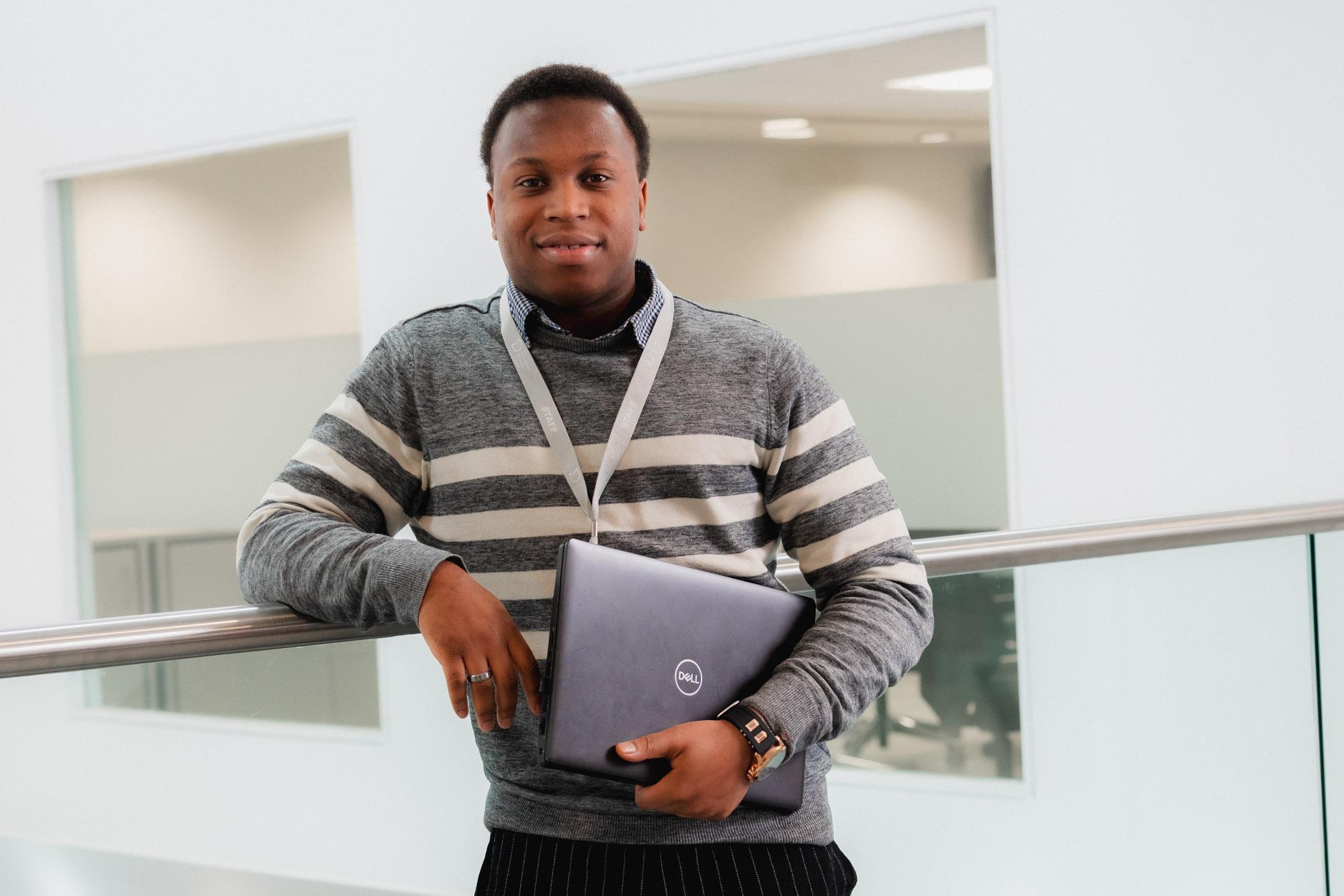 Man smiling holding laptop