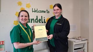 two girls standing holding a certificate