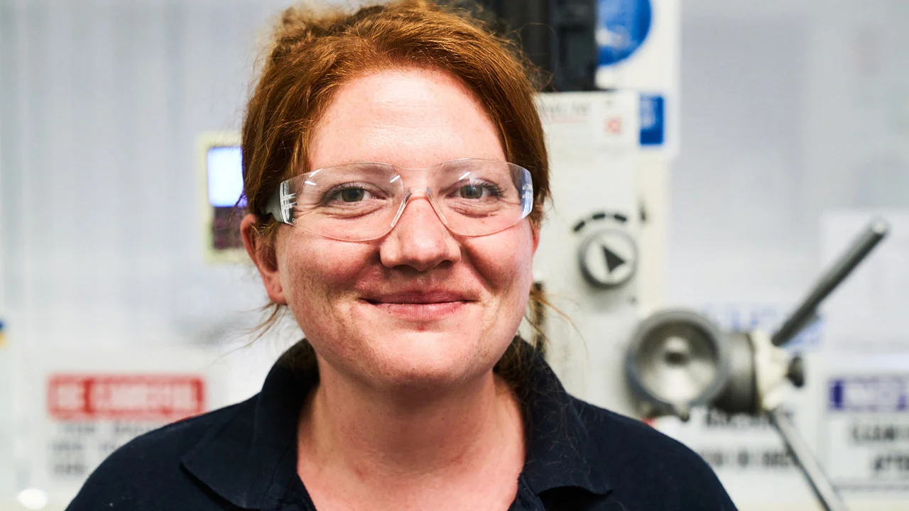 A portrait image of a smiling engineering technician