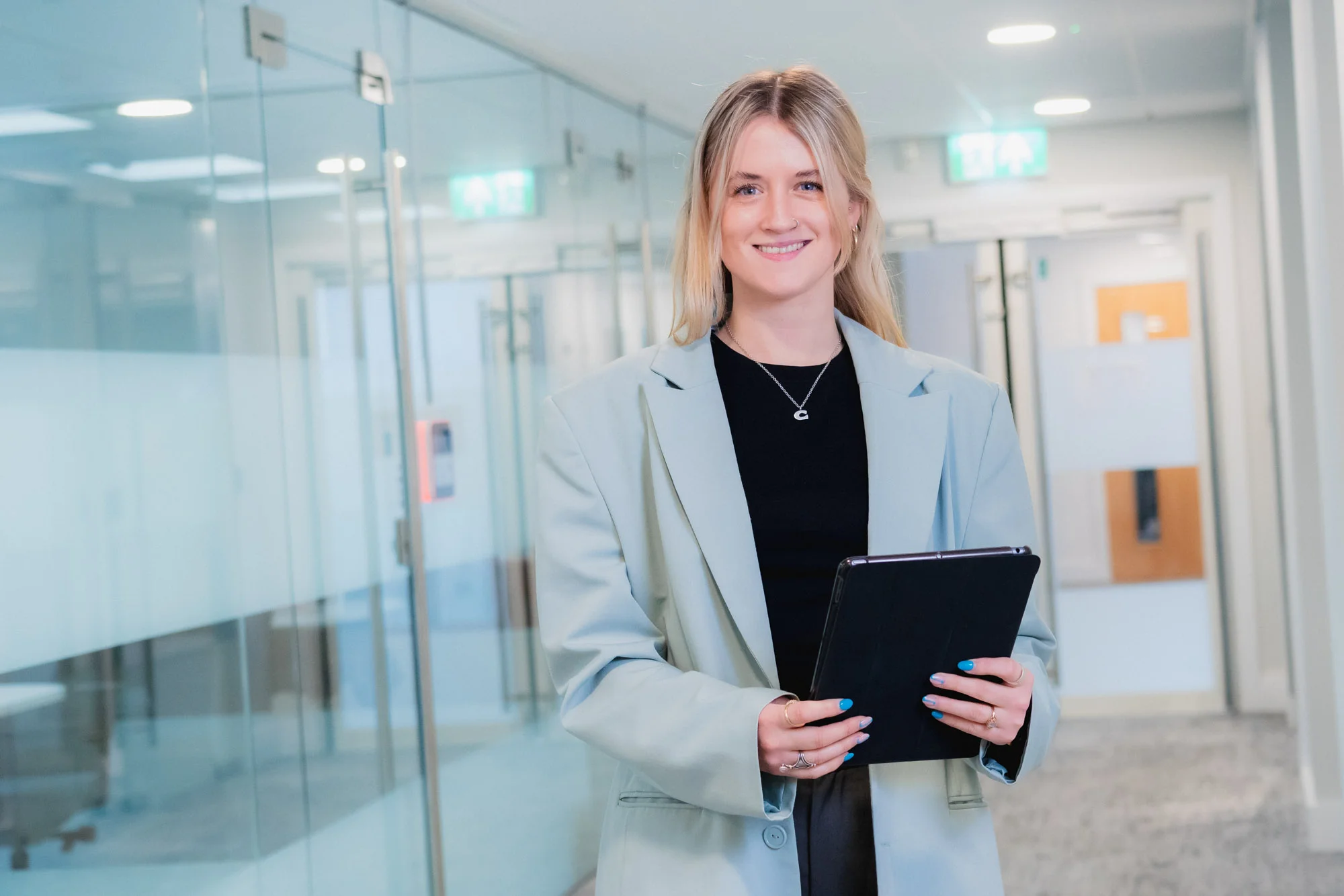 Lady standing with an ipad smiling