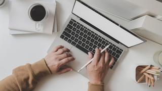 Close-up of someones hands typing on a laptop